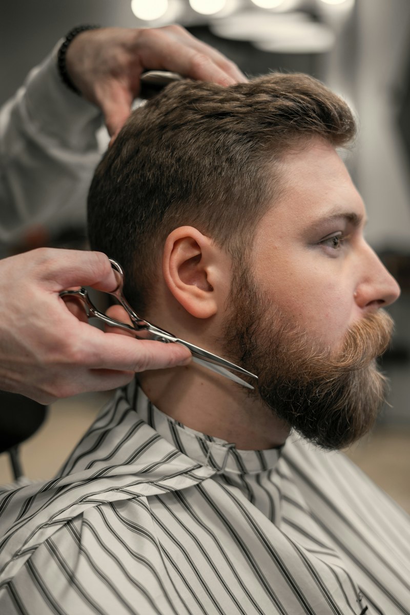 Barber trimming a beard with scissors
